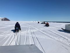 01B Ski-Doos Lead Qamutiik Sleds At The Beginning Of Day 1 With Bylot Island On Floe Edge Adventure Nunavut Canada